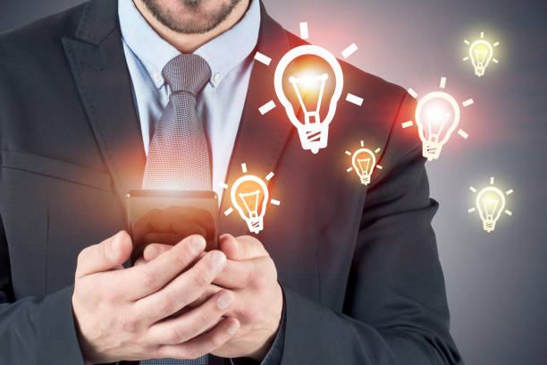istock Businessman with smartphone, lightbulbs 1141521198