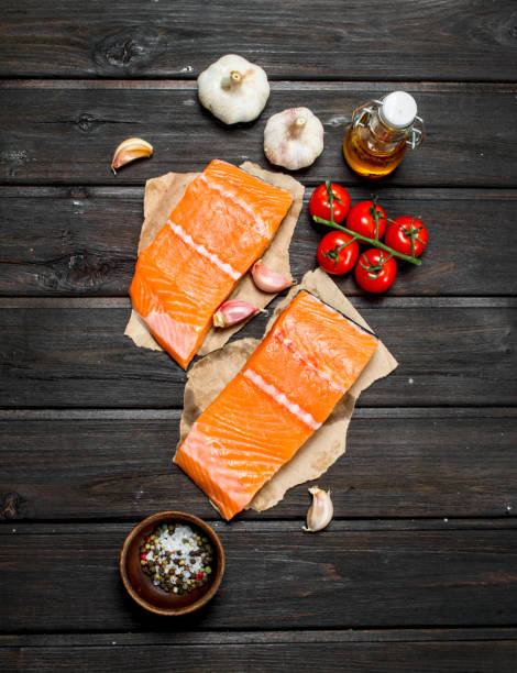 istock Raw salmon fish steaks with garlic and tomatoes. 1141521410