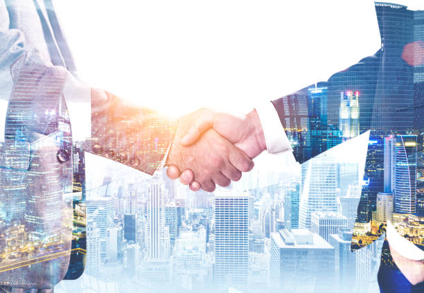 istock Businessmen shaking hands in modern city 1141522292