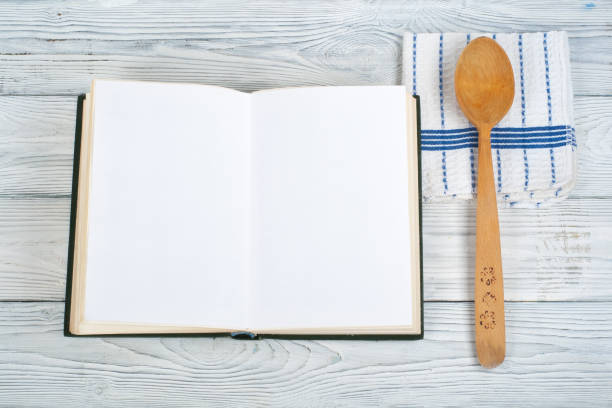 istock Recipe cook blank book on wooden background, spoon, rolling pin, checkered tablecloth. Top view 1141523029