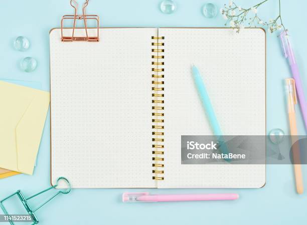 Blank Notepad Page In Bullet Journal On Blue Office Desktop Top View Of Modern Bright Table With Notebook And Flower Mock Up Copy Space Stock Photo - Download Image Now