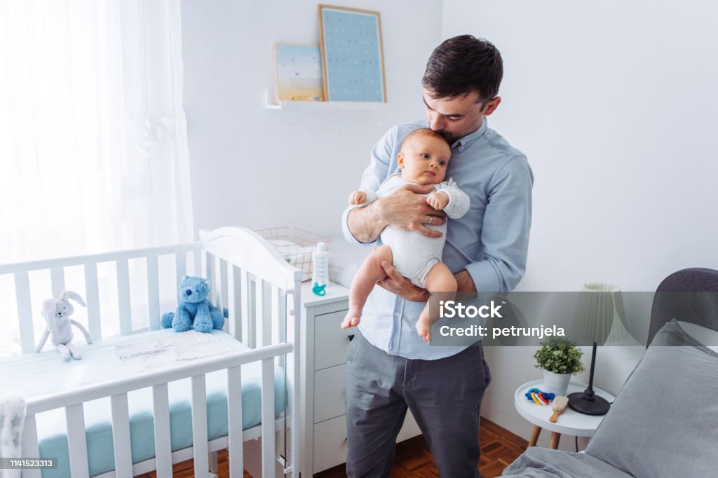 Fathers love Father carrying baby son in bedroom 2-5 Months Stock Photo