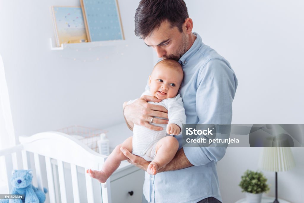 Fathers love Father carrying baby son in bedroom 2-5 Months Stock Photo