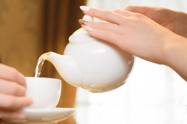 istock Tea party. Women pour green tea into a white Cup 1141523486