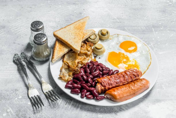 istock English breakfast. Fried eggs with sausages, bacon and beans. 1141524349