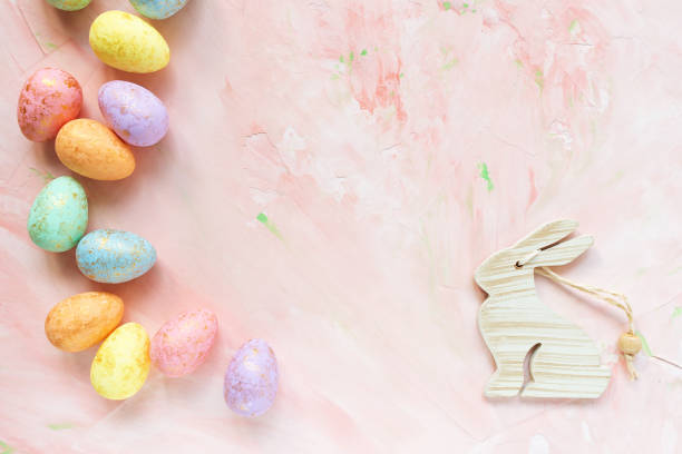 istock Multicolored eggs and rabbit decoration on a pink background. Easter celebration concept. 1141524351