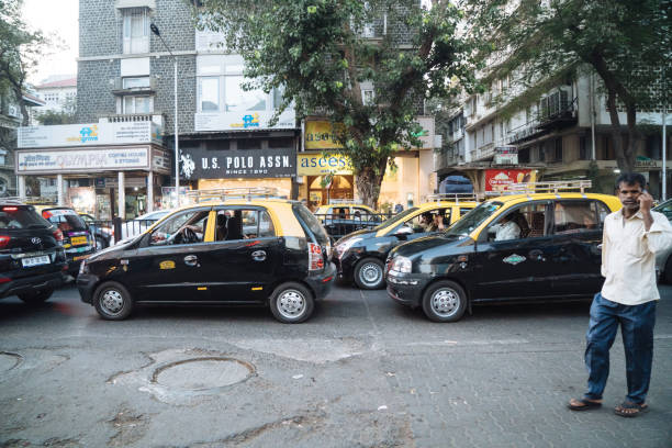 Mumbai, India - March 02, 2019: Photo of a typical taxi running fast on a common street in Mumbai. Indian drivers are used to drive very fast even if the streets are full of people, cows, dogs, bicycles, bus.'