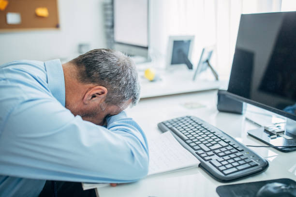 istock Senior businessman napping at the office desk 1141526618
