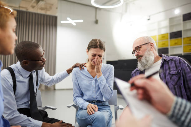istock Young Woman Crying in Support Group 1141527589