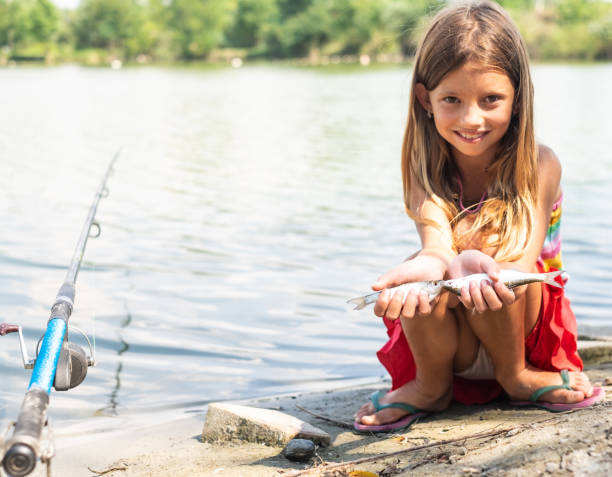 istock Portrait cute girl playing with two fish 1141528757