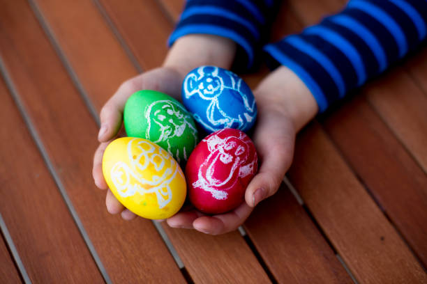 istock Colorful easter eggs with children drawings in child hands 1141528984