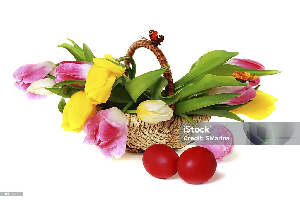 Huevos de Pascua y una canasta con coloridos tulipanes. - Foto de stock de Alimento libre de derechos