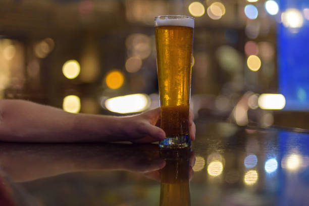 istock Man holding ice cold tall beer at the bar 1141529120