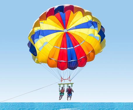 Pareja feliz parasailing en la playa de Turquía en verano. Un par bajo el paracaídas colgando medio aire. Divirtiendo. Paraíso tropical. Emociones humanas positivas, sentimientos, familia, hijos, viajes, vacaciones. photo
