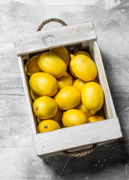 istock Fresh yellow lemons in wooden box. 1141529848