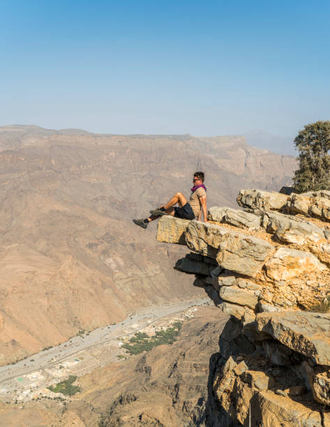 istock Man sitting on cliff in desert, Oman 1141530510
