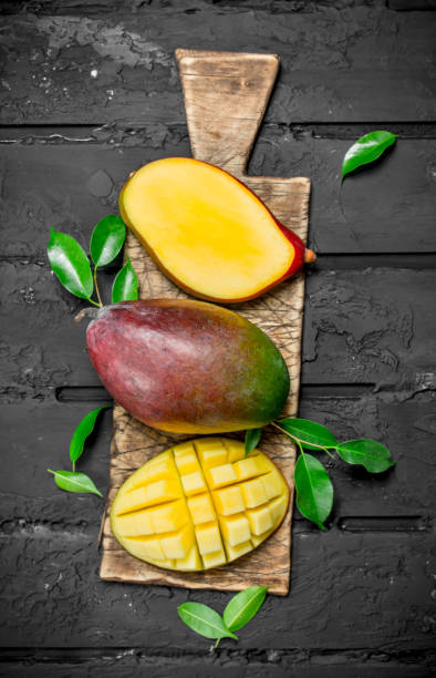 istock Whole and pieces of mango on the cutting Board. 1141530595