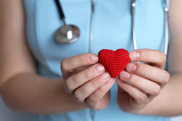 cardiología y cuidado de la salud, mujer médico sosteniendo el corazón rojo de punto en las manos - medical equipment stethoscope hospital blue fotografías e imágenes de stock