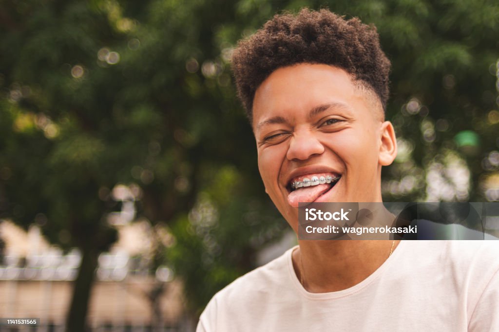 Portrait Of A Brazilian Guy Making A Funny Face With Eyes Closed And  Sticking Out Tongue Stock Photo - Download Image Now - iStock