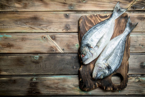 istock Raw sea fish dorado on a cutting Board. 1141532502