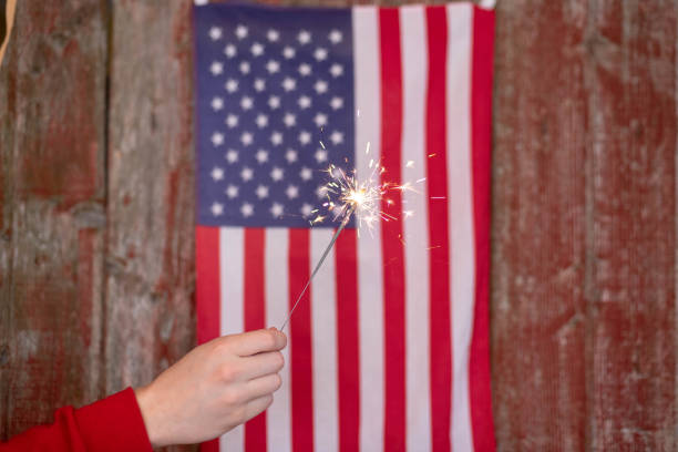 istock Holding a sparkler in front of American flag 1141533056