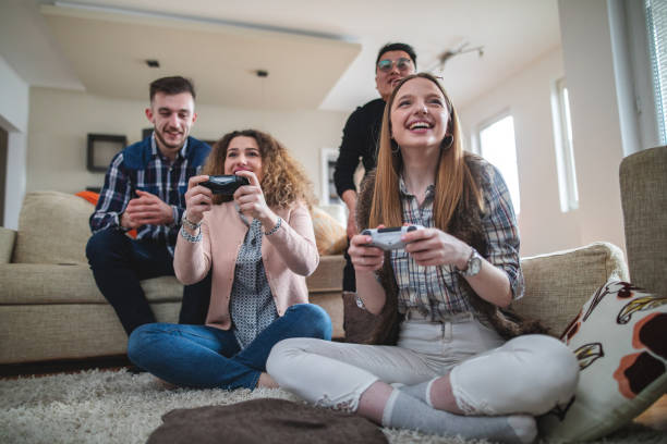 Young group of students having fun together at home, playing leisure games.