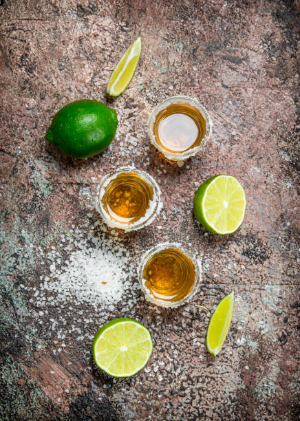 Tequila in a shot glass with salt and sliced lime.