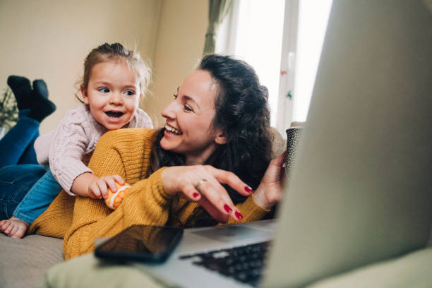 istock Mother and daughter using laptop on sofa 1141535187