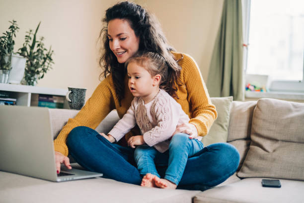 istock Mother and daughter using laptop on sofa 1141535188