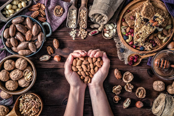 istock Woman hands holding a bunch of dried almonds on a table in a old fashioned rustic kitchen 1141537904