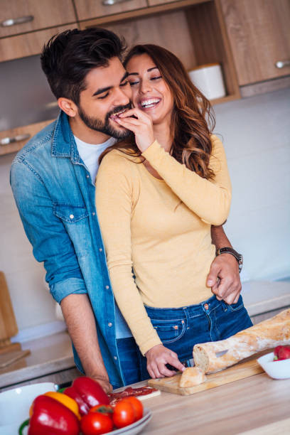 istock Happy couple showing affection in the kitchen. 1141538070