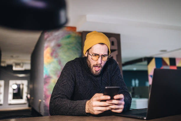 imprenditore hipster scioccato dalla notizia - beautiful office people shock foto e immagini stock