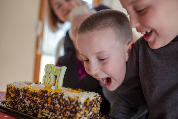 alte seniorin feiert ihren 87. geburtstag mit ihren lieben - long life cake birthday cake grandparent stock-fotos und bilder