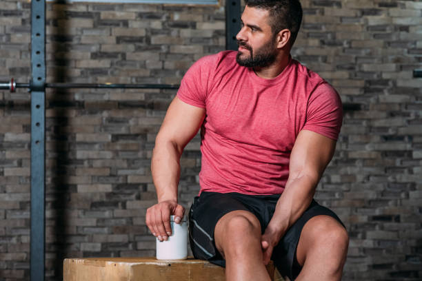 Muscular man holding sport nutrition product stock photo