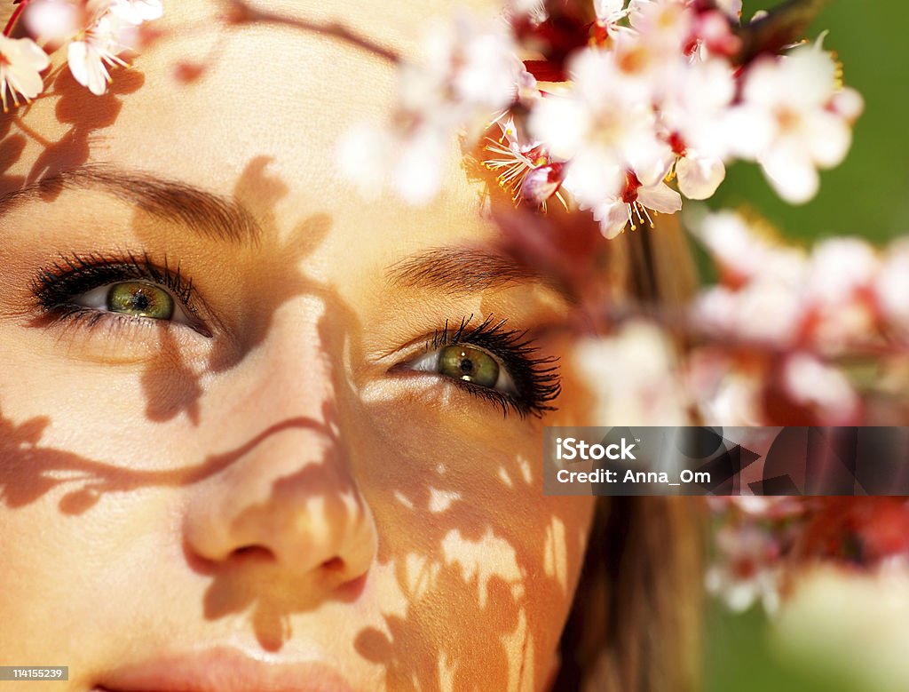 Giovane volto femminile con i fiori - Foto stock royalty-free di Adulto