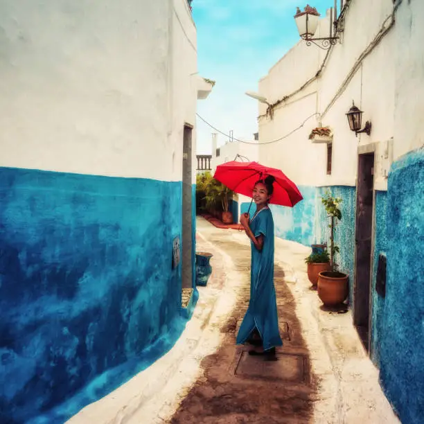 Photo of Asian Girl in Traditional Moroccan Dress with a Red Umbrella in