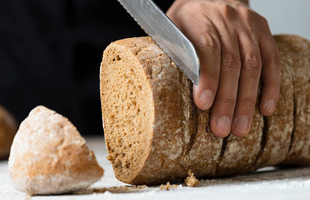 istock Woman Cutting Bread 1141557649