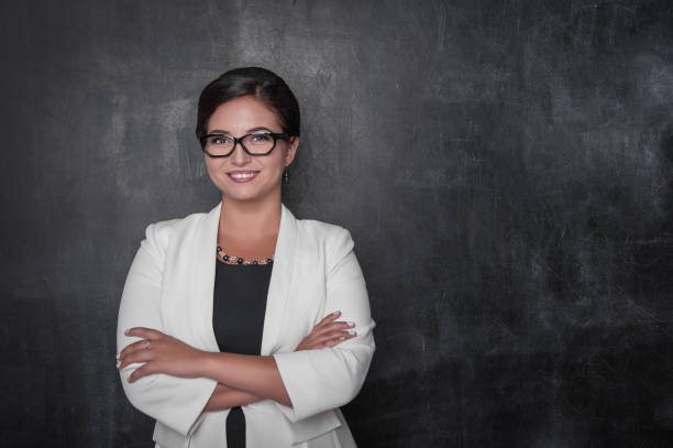 Happy smiling teacher with eyeglasses on blackboard stock photo