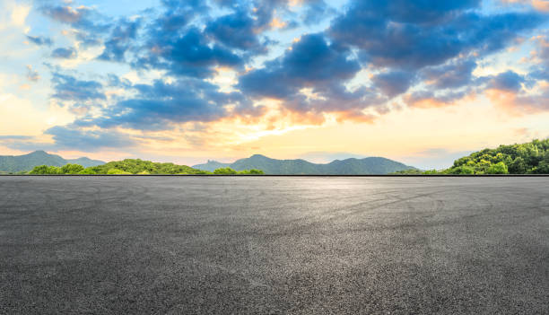 istock Asphalt race track and mountains with beautiful clouds at sunset 1141560926