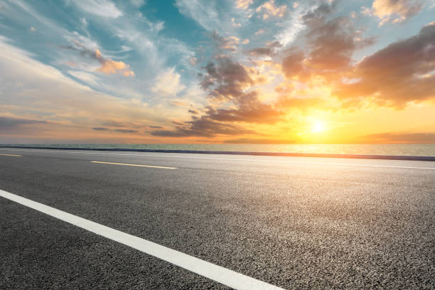istock Asphalt road and sea with beautiful clouds at sunset 1141563268