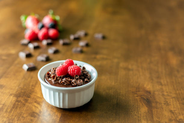 istock A decadent Chocolate Mousse Cake with chocolate ganache and topped with Raspberries, Blackberries and chocolate curls on a wood table in a ramekin dish 1141563471