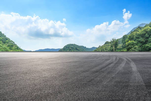 istock Asphalt race track and mountains with blue sky landscape 1141564809