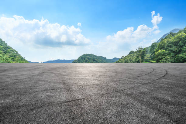 istock Asphalt race track and mountains with blue sky landscape 1141564884