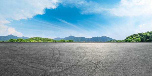 pista de asfalto vacío y montañas con paisaje de cielo azul - car horizon over land driving street fotografías e imágenes de stock