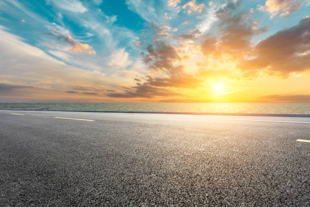 istock Asphalt road and sea with beautiful clouds at sunset 1141565655