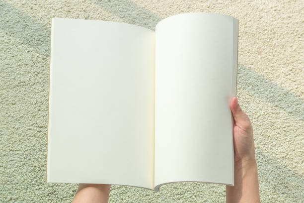 istock Blank open book mockup template in woman's hands with paper texture copyspace isolated on white background (clipping path) 1141566455