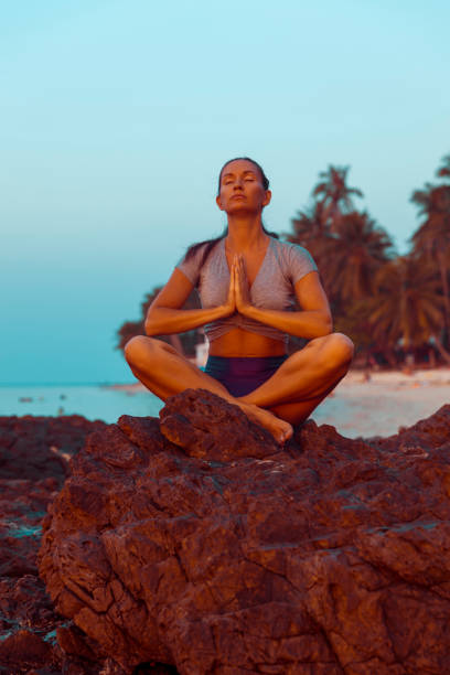 istock Woman practicing yoga on the beach 1141566977
