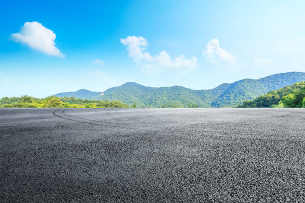 Asphalt race track and mountains with blue sky landscape stock photo