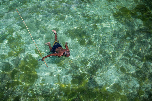 Borneo, Malaysia - 30th November, 2018 : A fisherman of the sea gypsies tribe is fishing with a traditional spear.