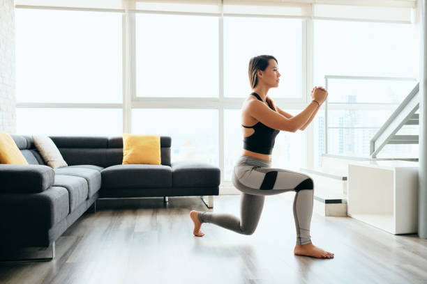 Adult Woman Training Legs Doing Inverted Lunges Exercise Fit young Pacific Islander woman training at home. Beautiful female athlete working out for wellbeing in domestic gym, training legs muscles doing lunges exercise woman legs open stock pictures, royalty-free photos & images